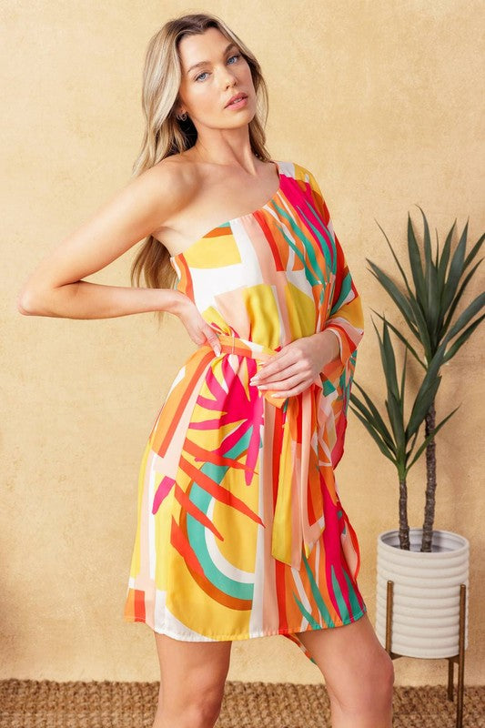 A printed woven kaftan mini dress featuring one shoulder neckline and self sash tie