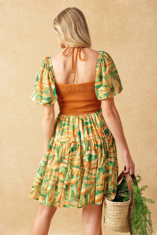 A crochet and print combination mini dress featuring crochet bodice with halter tie and beading, short puff sleeve and tiered skirt
