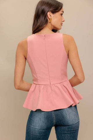 A solid woven top featuring V neckline, sleeveless, peplum and back zipper closure