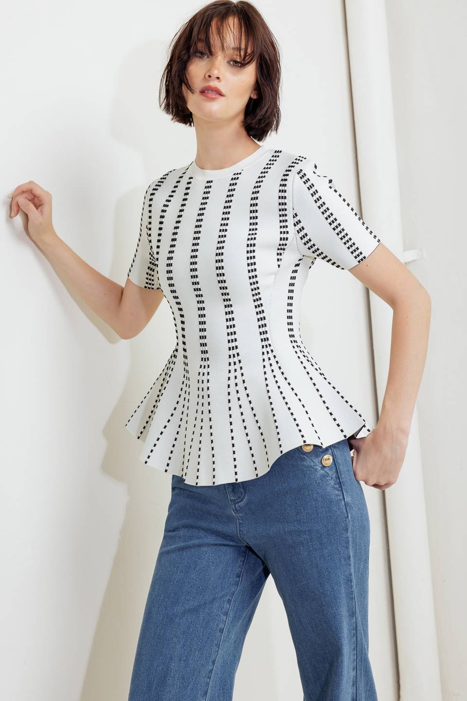 A jacquard sweater top featuring round neckline, short sleeve and peplum