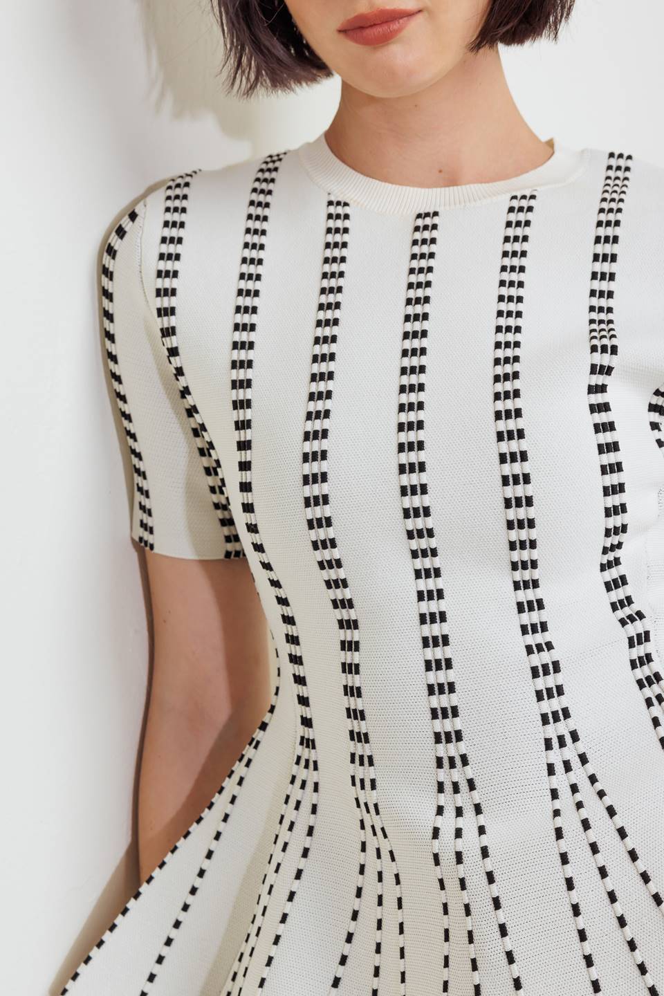 A jacquard sweater top featuring round neckline, short sleeve and peplum