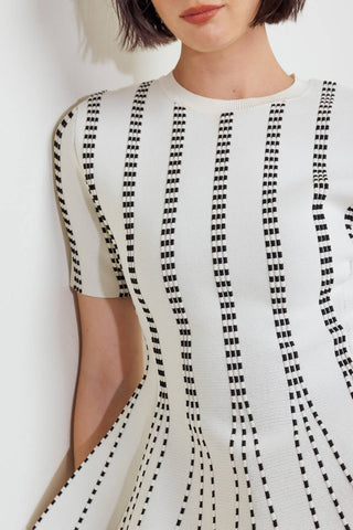 A jacquard sweater top featuring round neckline, short sleeve and peplum