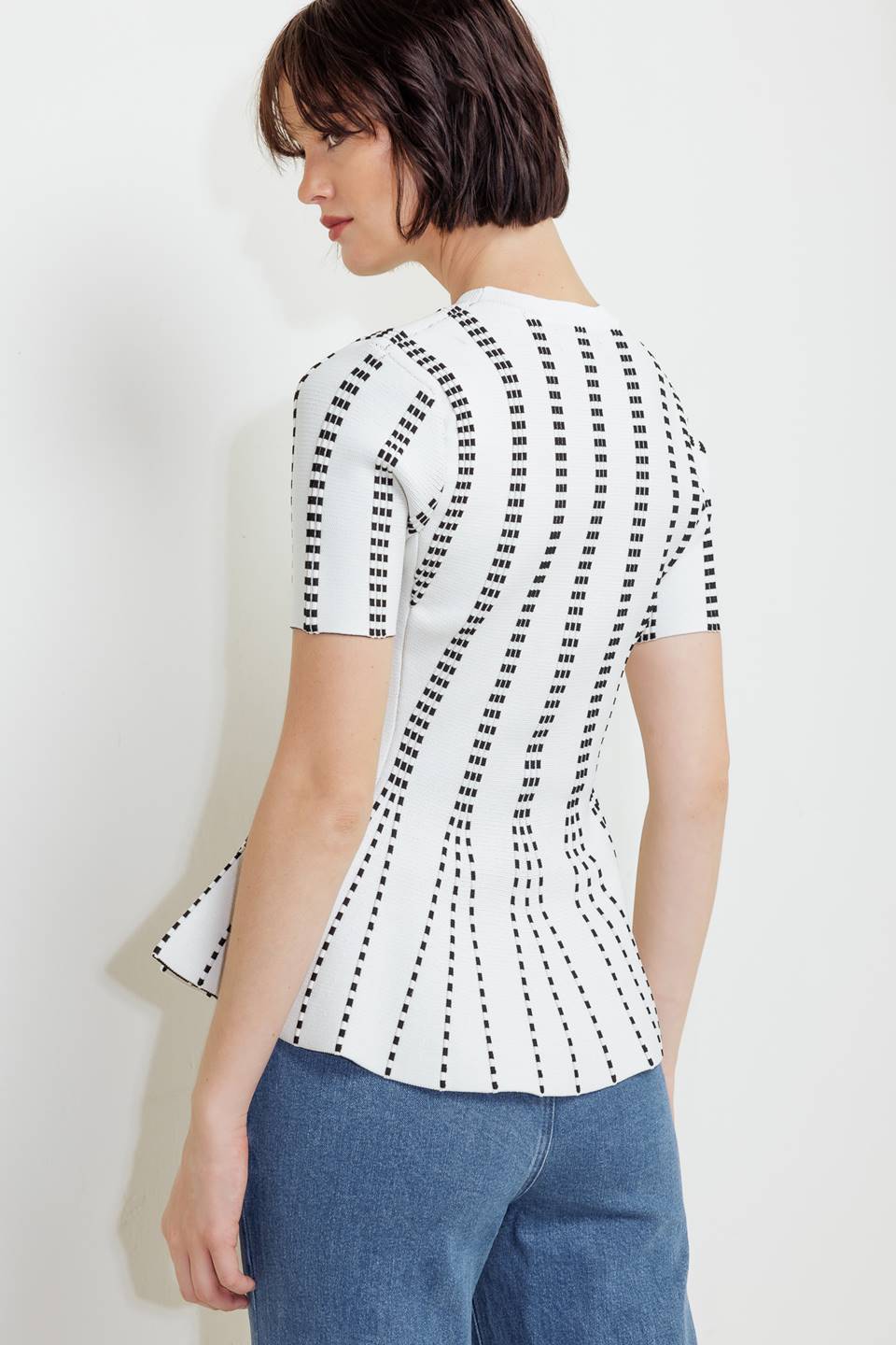 A jacquard sweater top featuring round neckline, short sleeve and peplum