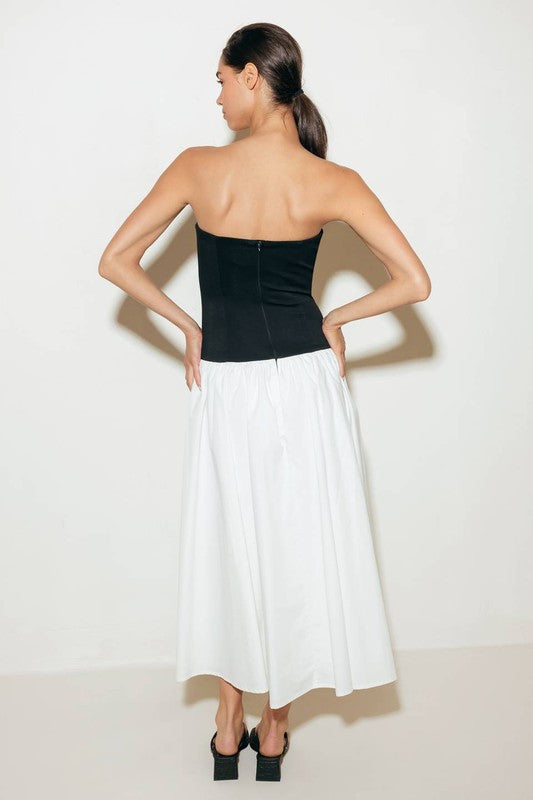 A solid midi dress featuring strapless knit bodice, full woven skirt and back zipper closure