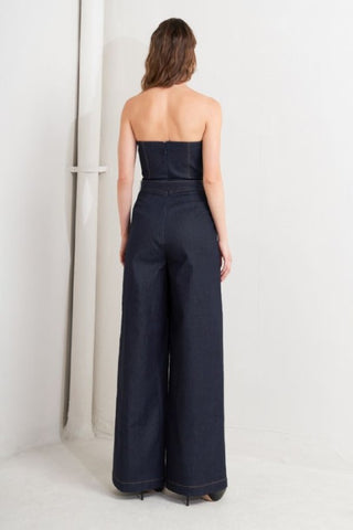 A denim jumpsuit featuring strapless, front fold over detail, self belt and wide leg