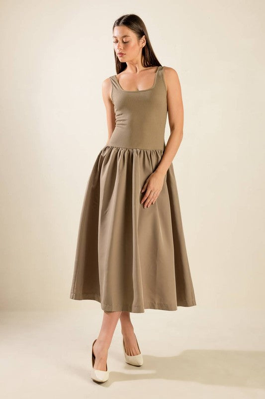 A solid knit/woven combination midi dress featuring ribbed tank bodice, dropped waist and full poplin skirt