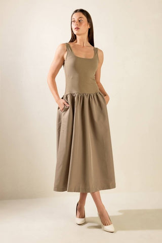 A solid knit/woven combination midi dress featuring ribbed tank bodice, dropped waist and full poplin skirt