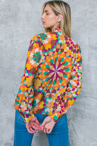 A printed woven top featuring high neckline with tie and long sleeve with cuff