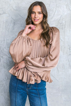 A solid woven top featuring sweetheart neckline, long sleeve and pleated bodice