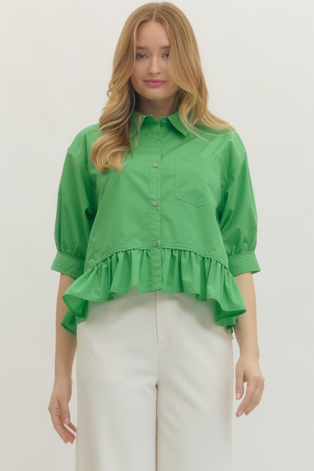 Solid 3/4 sleeve button-down top featuring ruffle hem detail