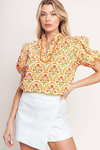 A printed woven top with ruffle neck with V front and short puff sleeve