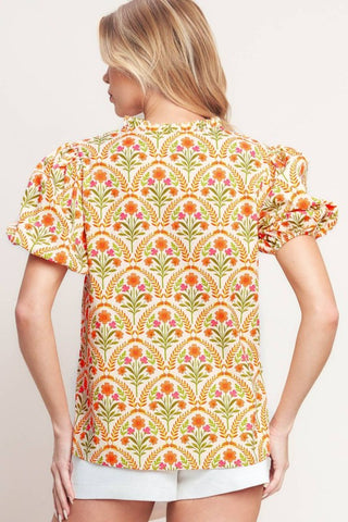 A printed woven top with ruffle neck with V front and short puff sleeve