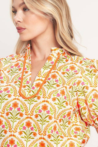 A printed woven top with ruffle neck with V front and short puff sleeve