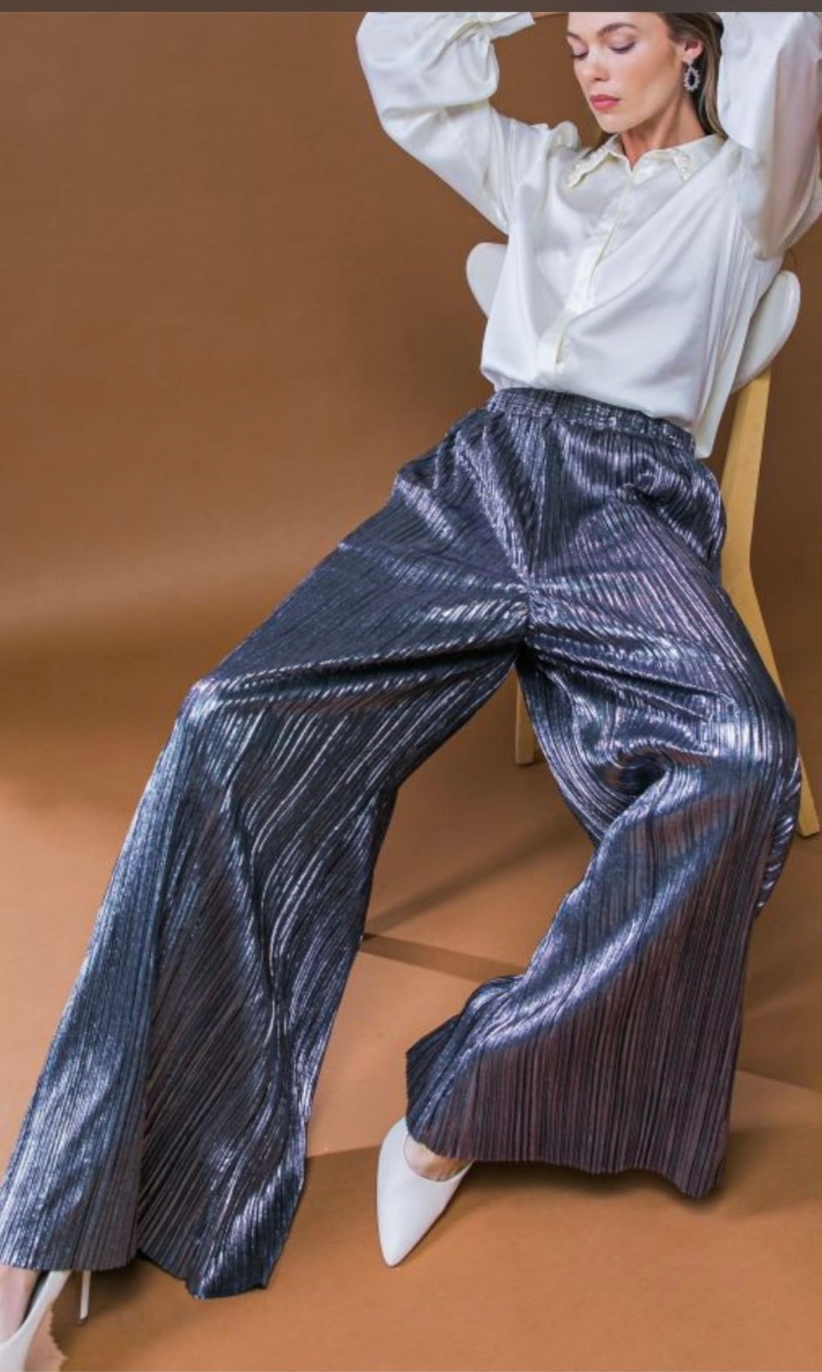 A woven pleated pant featuring elasticized waist and wide leg