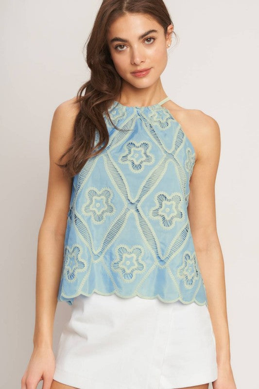 A woven embroidered top with halter neckline with back tie/tassel