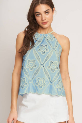 A woven embroidered top with halter neckline with back tie/tassel
