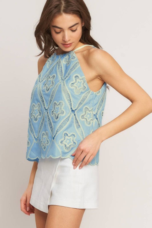 A woven embroidered top with halter neckline with back tie/tassel