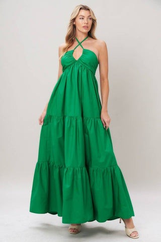 A solid woven maxi dress featuring shirred twist front bodice, tier skirt, back neck tie and smocked back bodice
