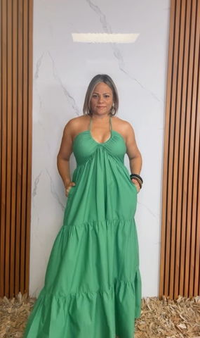 A solid woven maxi dress featuring shirred twist front bodice, tier skirt, back neck tie and smocked back bodice