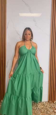 A solid woven maxi dress featuring shirred twist front bodice, tier skirt, back neck tie and smocked back bodice