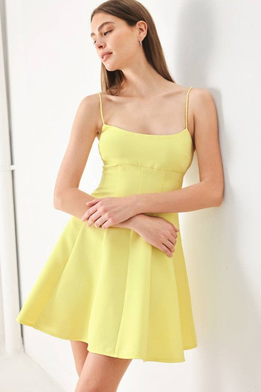 A solid woven cami dress with strap, circle skirt and back zipper closure