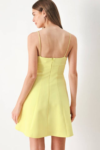 A solid woven cami dress with strap, circle skirt and back zipper closure