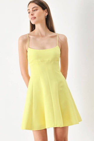 A solid woven cami dress with strap, circle skirt and back zipper closure