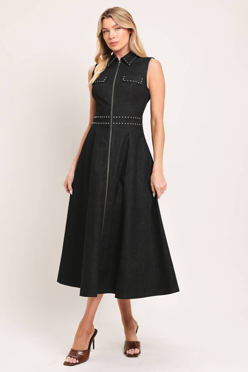 A solid woven midi dress featuring collar, sleeveless, front zipper closure, stud embellishments, side pockets and circle skirt