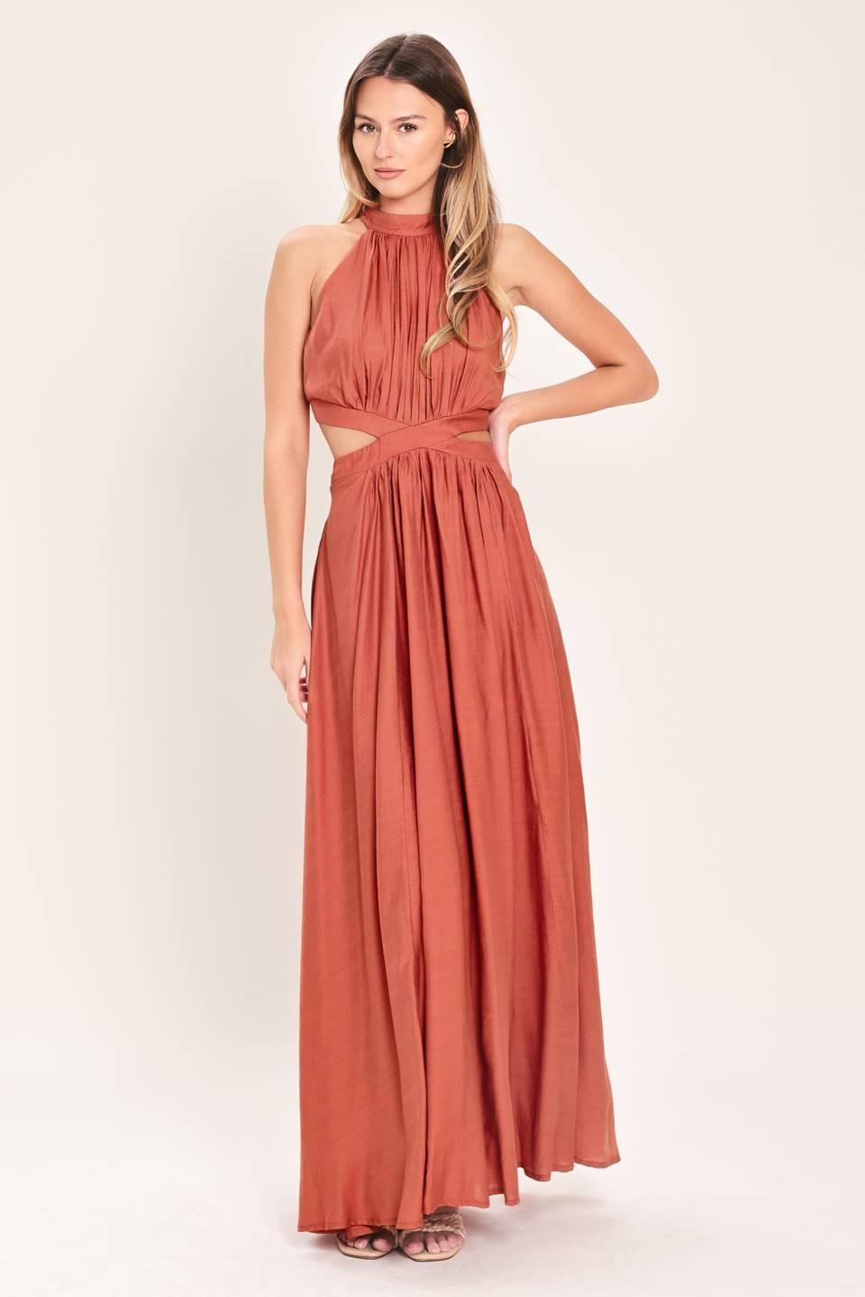 A solid woven maxi dress featuring halter neckline, side cut out and back button/zipper closure