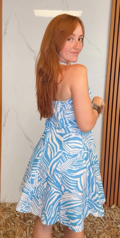 A printed woven mini dress featuring Queen Anne halter neckline, full circle skirt, bare back and zipper closure