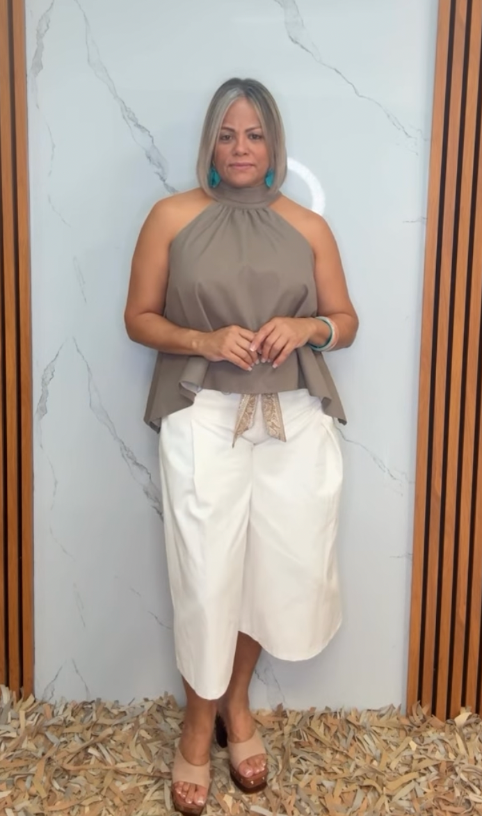 A solid woven culotte pant featuring front closure, pockets and printed sash