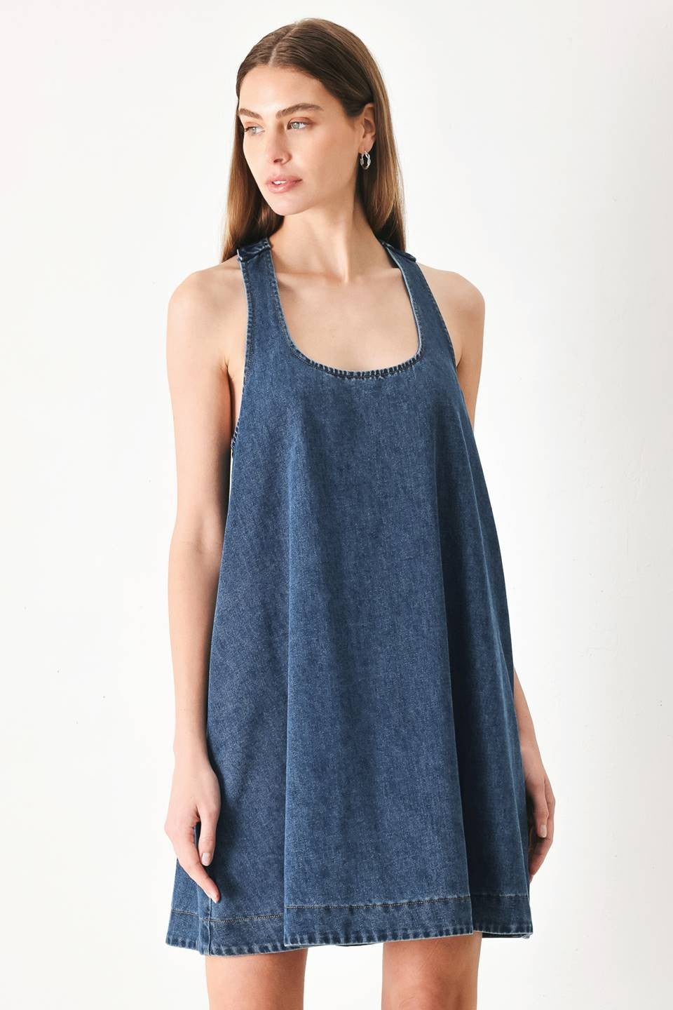 mini denim dress  A washed denim mini dress with halter neckline and racer back with buckle detail