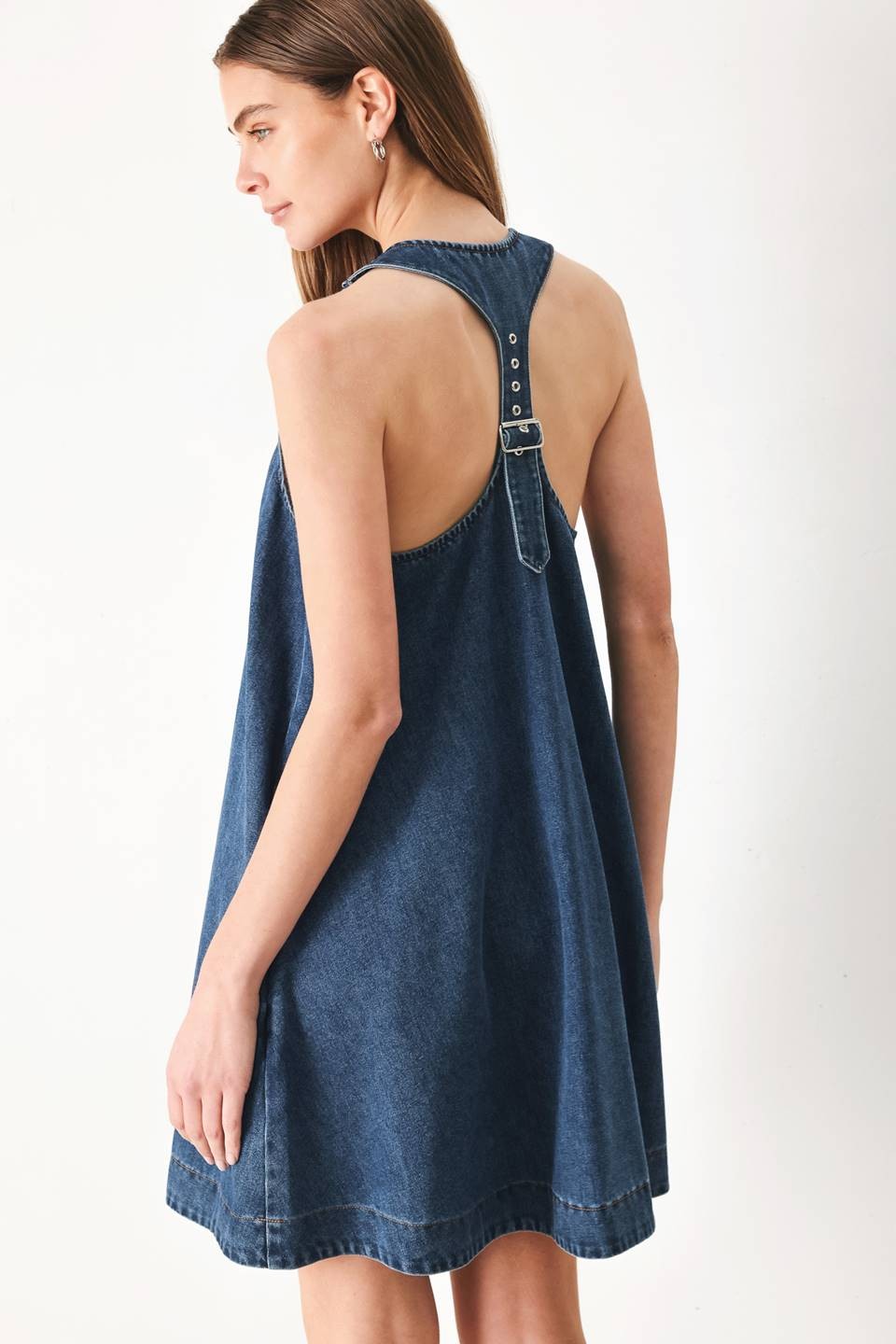 mini denim dress  A washed denim mini dress with halter neckline and racer back with buckle detail