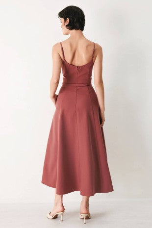 A solid woven midi dress featuring cam top, cut out at waistline, self belt, circle skirt and back zipper closure