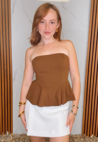 A solid woven tube top with peplum and back zipper closure