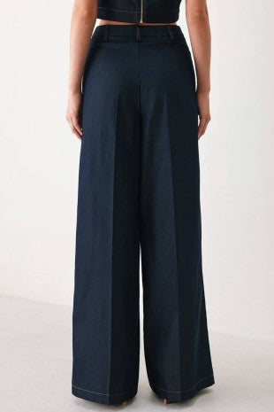 A solid woven wide leg pant with front closure and hardware detail