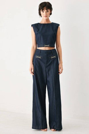 A solid woven wide leg pant with front closure and hardware detail