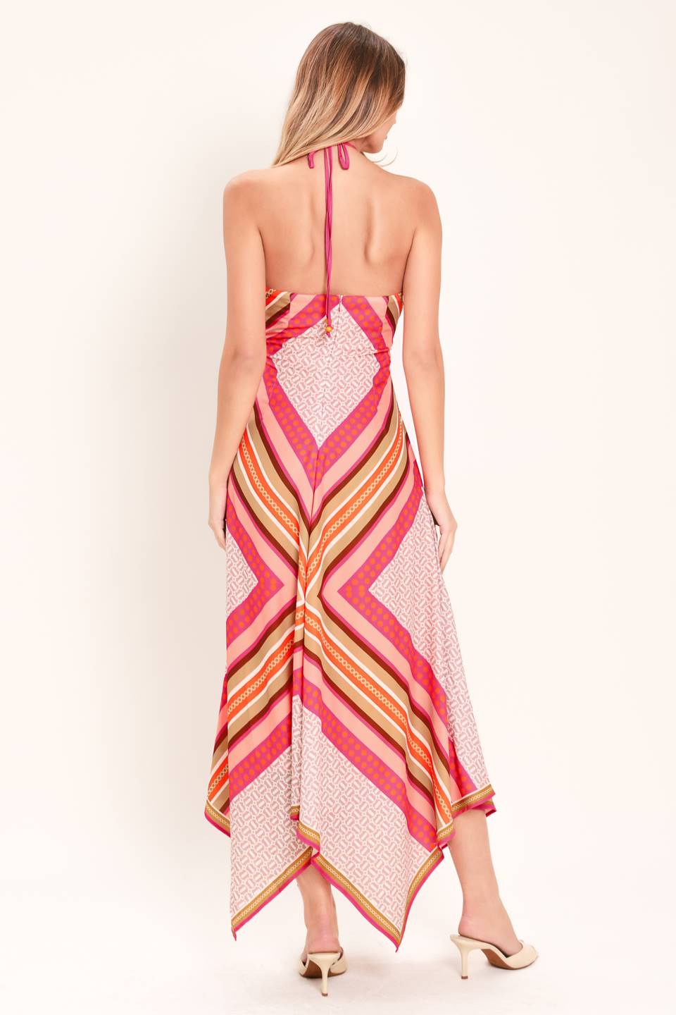 A printed woven midi dress featuring halter neckline with tie, hanky hem and back zipper closure
