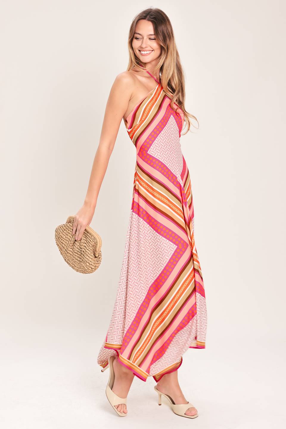 A printed woven midi dress featuring halter neckline with tie, hanky hem and back zipper closure