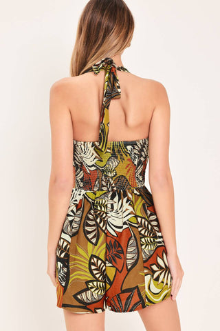 A printed woven romper featuring halter neckline and smocked back bodice
