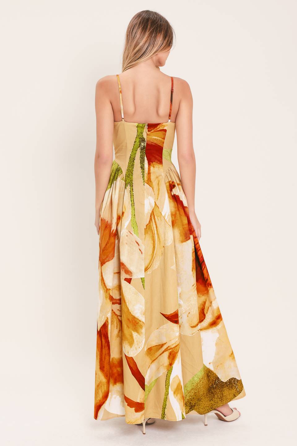 A printed woven maxi dress featuring bustier top, straps, side shirring detail and back zipper closure