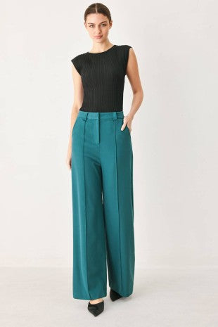 A solid woven pant featuring front closure, side pockets and wide leg