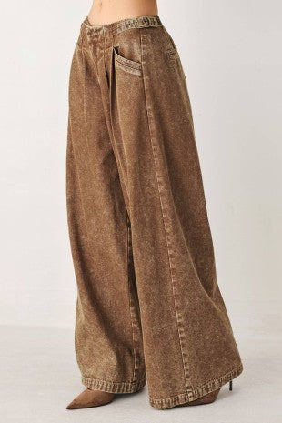 A washed denim pant featuring front closure, pockets and side buckle detail at waist