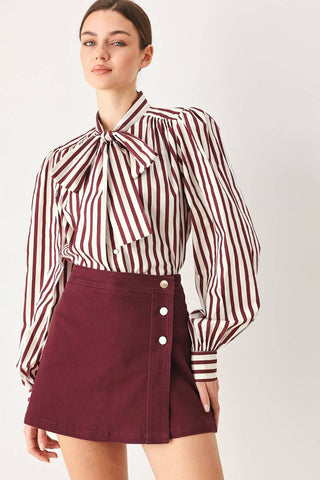 A solid woven skort with front closure and button detail