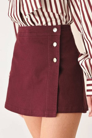 A solid woven skort with front closure and button detail