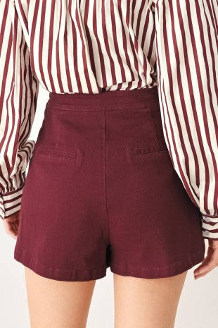 A solid woven skort with front closure and button detail