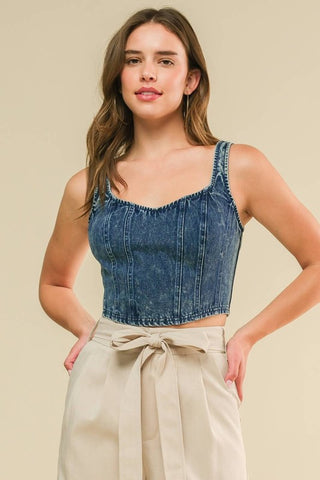 An acid washed cropped denim tank top with back zipper closure