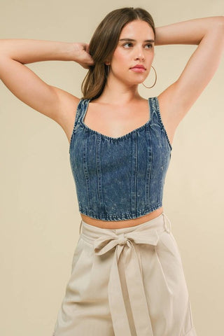 An acid washed cropped denim tank top with back zipper closure