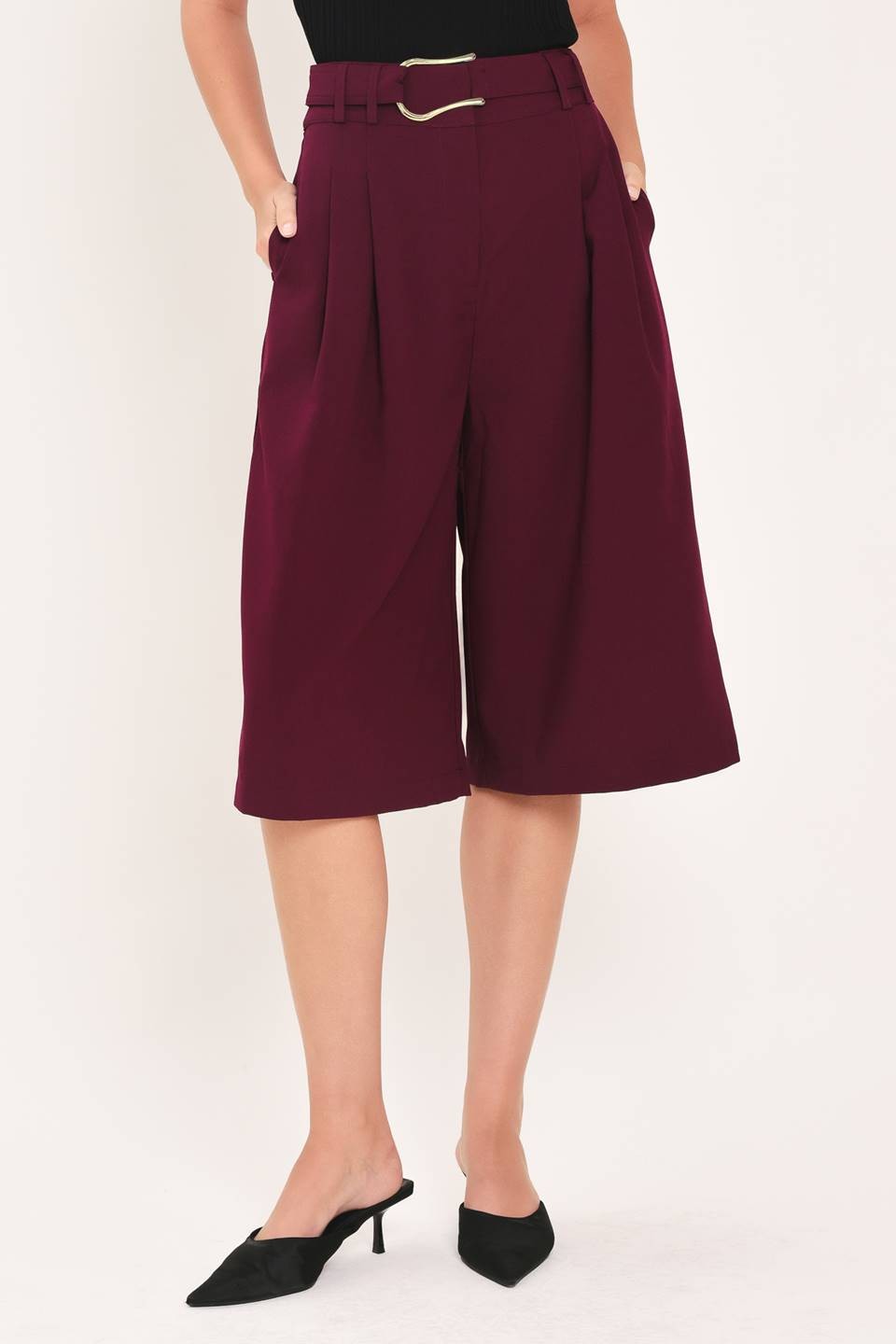 A solid woven culotte pant with buckle belt and front closure