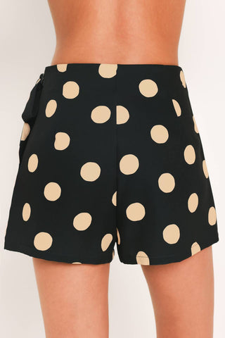 A printed woven skort featuring front overlay, side tie and zipper closure.
